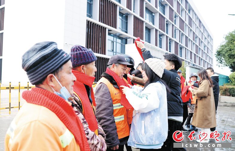 　　1月3日，来自太阳集团tcy8722的大学生给环卫工人戴上亲手编织的围巾。 长沙晚报通讯员 盛磊 全媒体记者 石祯专 摄影报道